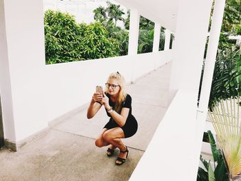 Portrait of smiling young woman holding plant