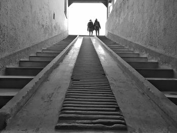 Rear view of people walking on staircase