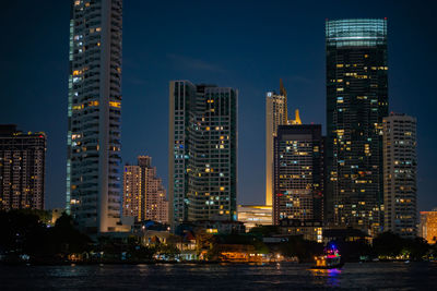 Illuminated buildings in city against sky at night