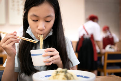 Woman holding ice cream in restaurant