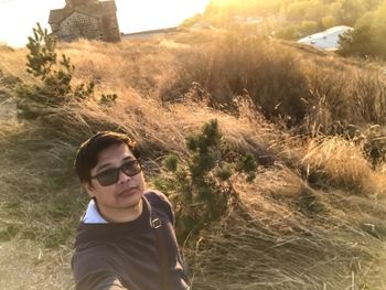 Portrait of young man wearing sunglasses standing on land