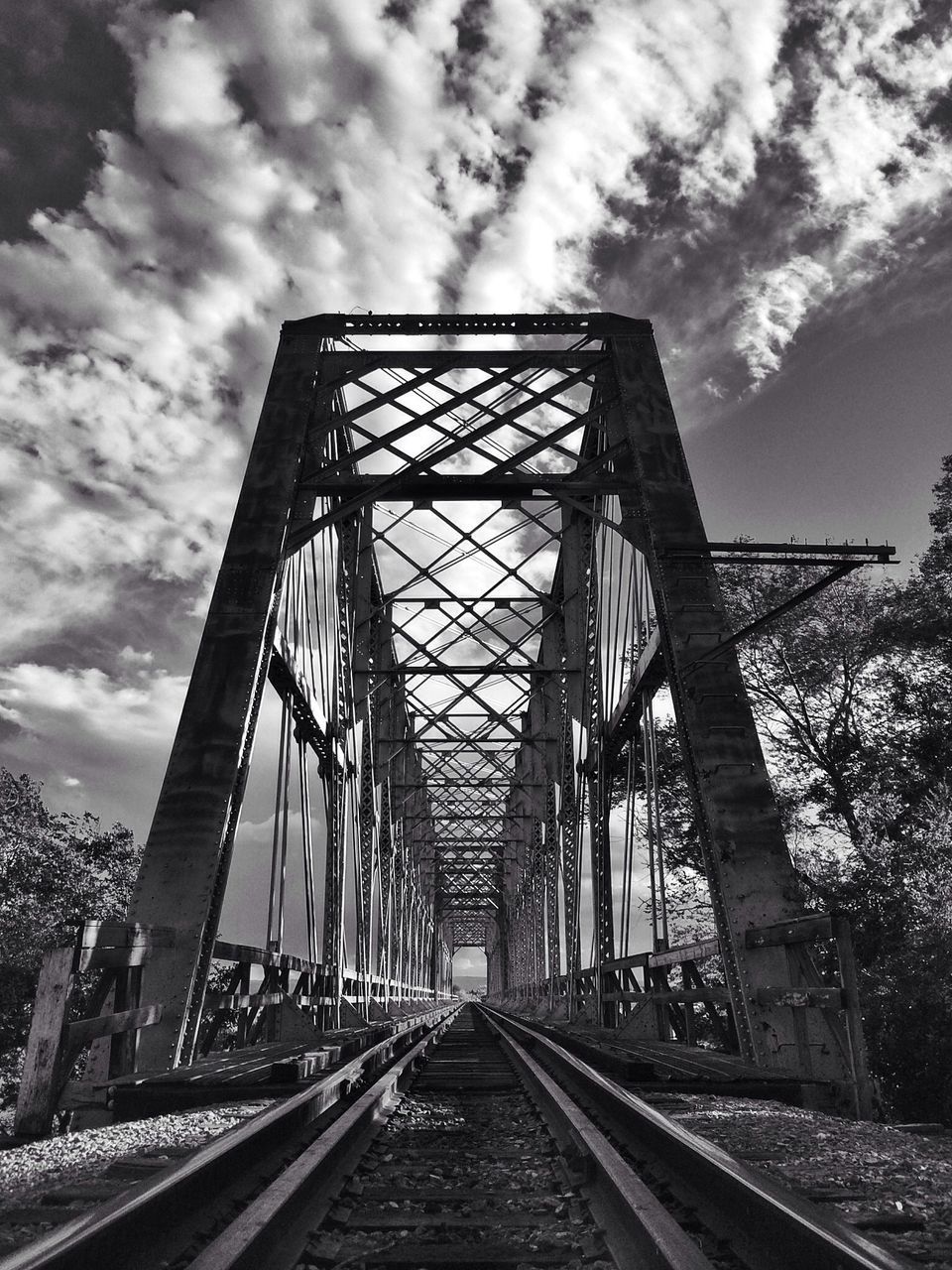 sky, cloud - sky, built structure, architecture, cloudy, the way forward, connection, cloud, railing, diminishing perspective, low angle view, bridge - man made structure, day, transportation, no people, outdoors, vanishing point, metal, railroad track, weather