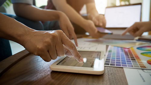 Midsection of woman using smart phone on table