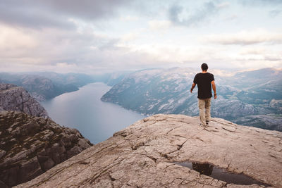 Man walking at edge of cliff at preikestolen, norway