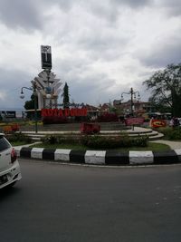 Cars on road against sky in city