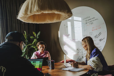 Woman with colleagues working at desk in conference room