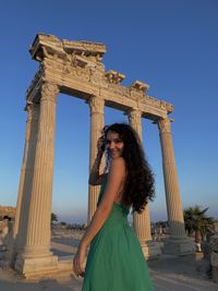 Young woman standing against historic building