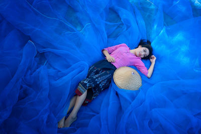 High angle view of young woman lying on net