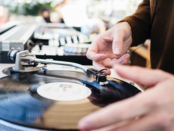 Midsection of man playing record