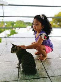 Full length of girl with cat in balcony