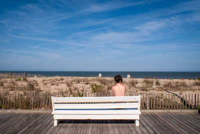 Rear view of woman looking at sea against sky