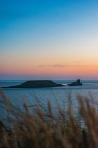 Scenic view of sea against clear sky at sunset