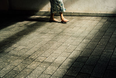 Low section of woman walking on floor