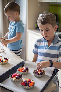 Boys preparing dessert in kitchen
