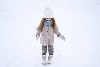 Full length of woman standing on snow covered field