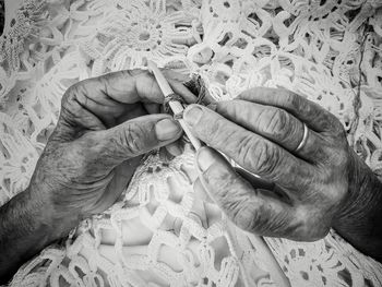 Cropped hands of senior woman knitting string