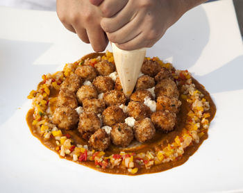 Cropped image of chef decorating food with icing bag