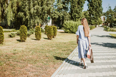 Rear view of woman walking on footpath at park