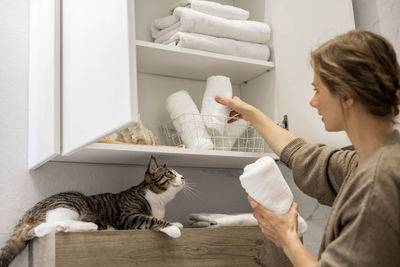 Side view of woman holding cat