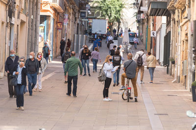 People walking on footpath in city