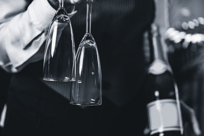 Close-up of bartender holding champagne flutes at bar