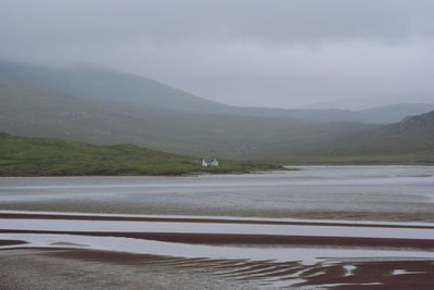 Scenic view of lake by mountains against sky