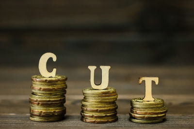 Close-up of coins with cut text on table