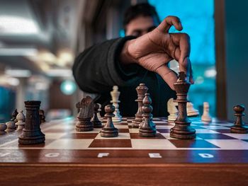 Low angle view of man playing on chess board