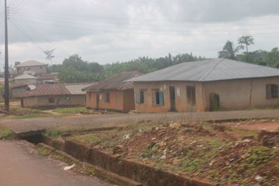 Houses on field by buildings against sky