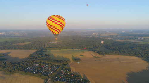 Hot air balloons flying over landscape against sky