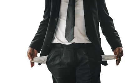 Midsection of man holding umbrella against white background