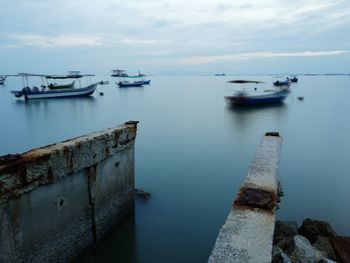 Boats moored on sea against sky