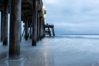 Wooden pier on sea against sky