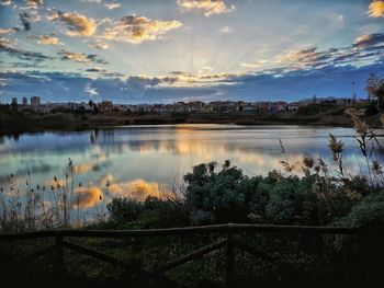 Scenic view of lake against sky at sunset