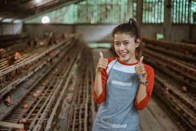 Portrait of young woman standing in greenhouse