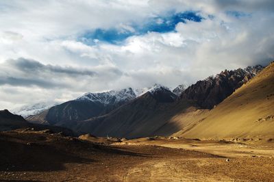 Scenic view of mountains against cloudy sky