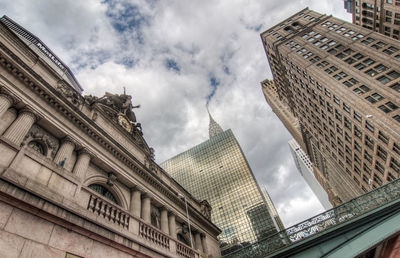 Low angle view of buildings against cloudy sky