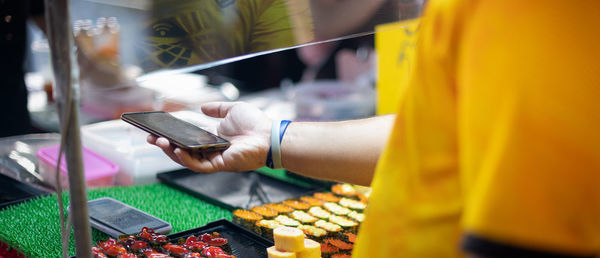 Buyer preparing a smartphone with the scan qr code for pay the money to seller.