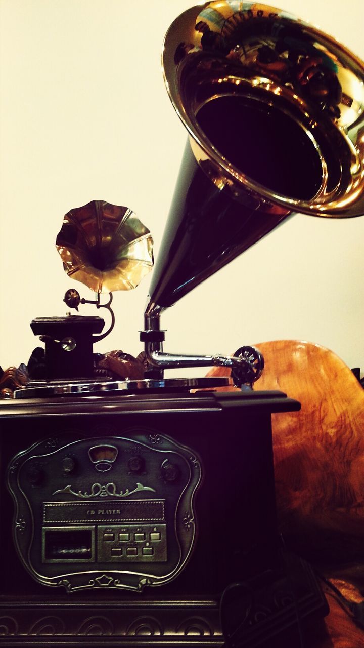 indoors, arts culture and entertainment, old-fashioned, close-up, retro styled, technology, music, still life, musical instrument, illuminated, single object, low angle view, no people, antique, metal, guitar, focus on foreground, communication, lighting equipment, photography themes