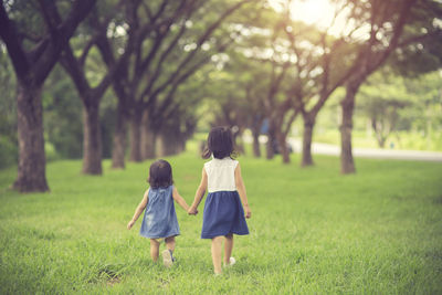 Rear view of women walking on field