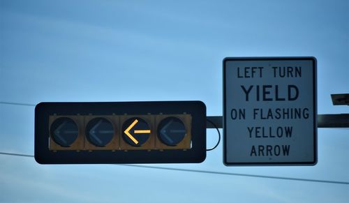 Close-up of road sign against sky