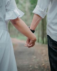 Midsection of couple holding hands