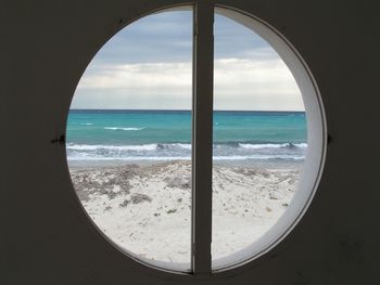 Scenic view of sea against sky seen through window