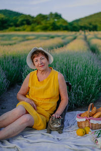 Portrait of young woman sitting on field