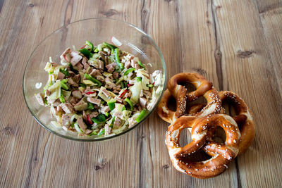 High angle view of pretzel and salad on table