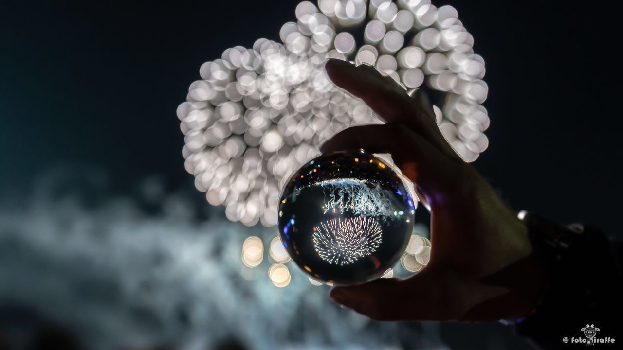 CLOSE-UP OF HAND HOLDING ILLUMINATED CRYSTAL