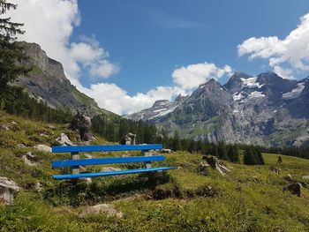 Scenic view of field and mountains against blue sky