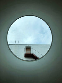 A modern architecture. circle window. urban view with stairs and sky.