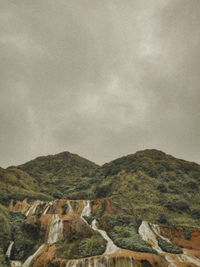 Scenic view of mountains against cloudy sky