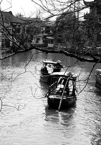 Boat in river against bare trees